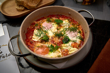 A Delicious Dish of Eggs Poached in Spicy Tomato Sauce, Garnished with Fresh Herbs in a Rustic Dish Perfect for Any Meal.