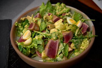 A Colorful and Fresh Salad Featuring Leafy Greens, Tender Tuna, Cherry Tomatoes, Hard-Boiled Eggs, and Olives for a Healthy and Delicious Meal