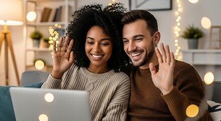 Happy couple video chatting on laptop, waving hello from cozy living room.