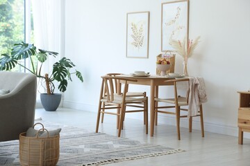 Beautiful table setting, chairs and decor in dining room. Interior design
