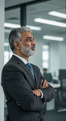Confident Business Executive Posing With Arms Crossed While Looking Away in Office