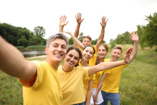 Team building. Group of happy people taking selfie outdoors