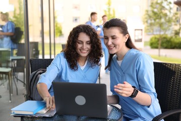 Medical students studying together in outdoor cafe, selective focus