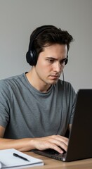 Focused Man Working With Headphones Using Laptop Computer On Desk Indeed.