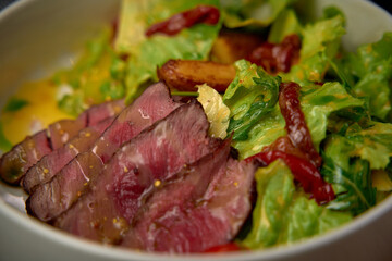 A Delicious Plate of Sliced Beef Accompanied by Fresh Mixed Greens and a Medley of Colorful Vegetables for a Wholesome Meal Experience