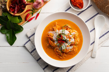 Prawns with dried red curry sauce.Thai curry paste (Chu Chee goong) stir-fried with coconut milk and shrimp in white plate.Top view.