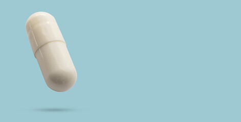 White medicine pill capsule float on blue background