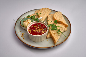 A Delicious Plate of Freshly Baked Bread Accompanied by Flavorful Dipping Sauce and Lightly Garnished Peas for a Perfect Snack