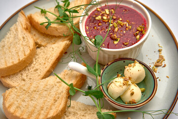 A Deliciously Presented Plate Featuring Savory Bread, Creamy Dessert, and Nutty Fruit Spread with Fresh Greens for a Satisfying Culinary Experience