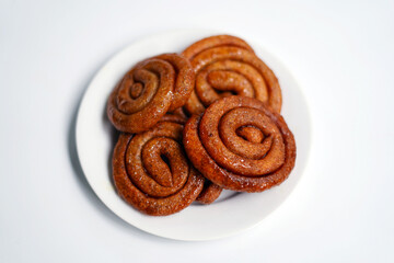 Crunchy Swirl Candies Arranged on White Plate over White Background