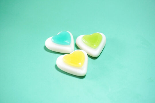 brightly colored jelly candy shape heart isolated on pastel blue background