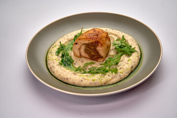 Deliciously Plated Chicken Roulade Served on a Creamy Herb Sauce with Fresh Arugula Garnish