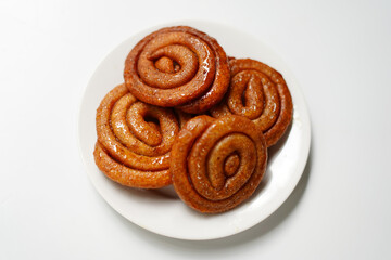 gold color Spiral Hard Candies in White Dish on Minimal White Backdrop