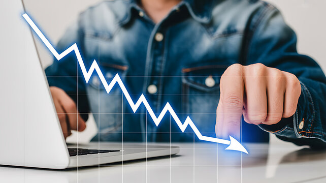 Man analyzing downward financial trend on laptop showing loss or decline in business performance and investment returns and potential economic crisis