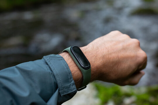 fitness tracker on a man's hand in the forest near river