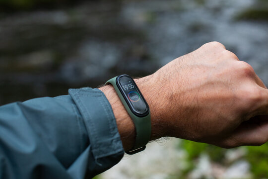 fitness tracker on a man's hand in the forest near river
