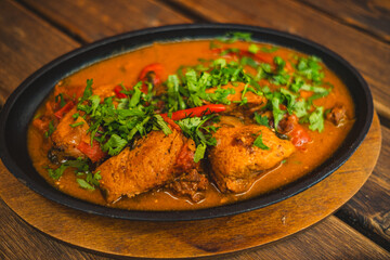 Enjoy the art of dining as chicken chakhokhbili is served with vibrant herbs and spices in a rustic atmosphere Experience the rich taste and cultural essence