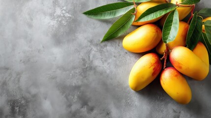 Flat lay of mangoes on a gray surface with designated area for textual content