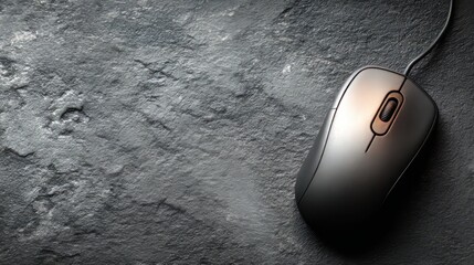 One wired computer mouse placed on a textured dark table with room for text