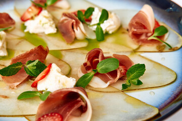 Delicate Charcuterie Plate Featuring Thinly Sliced Meats, Creamy Cheese, and Fresh Herbs Laid Elegantly on a Vibrant Platter for an Appetizing Presentation