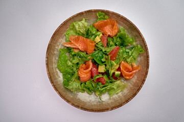 Fresh Mixed Green Salad topped with Delicate Smoked Salmon, Vibrant Vegetables, and a Stir of Colors for a Nutrient-Packed Meal Experience