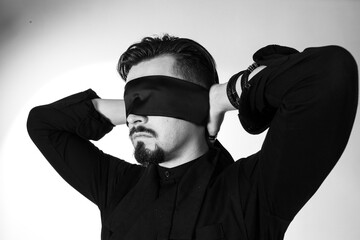 A man with his eyes blindfolded. Studio photo
