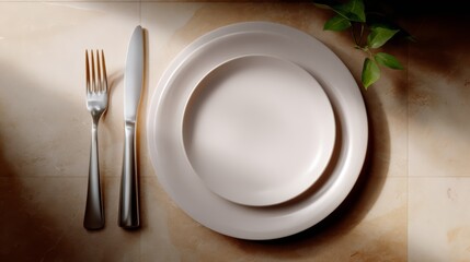 White plate with a fork and knife on it. The fork is on the left and the knife is on the right