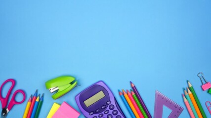 Colorful school supplies moving bottom border. Top view stop motion loop video over a blue background. Back to school concept. - Powered by Adobe