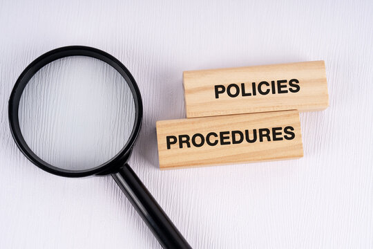 Magnifying glass and text policies and procedures on white background