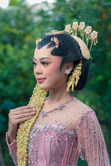 Close-up of an elegant Asian bride in traditional Javanese kebaya, showcasing intricate jasmine...