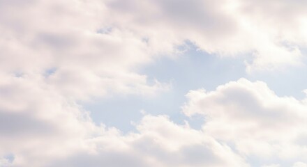 Fototapeta premium Soft fluffy white clouds drift across a pale blue sky