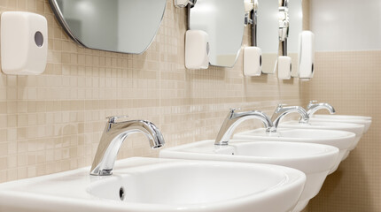 Fototapeta premium Row of Modern Bathroom Sinks with Tiled Wall