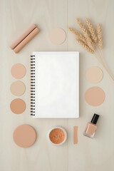 The wooden art and beauty supply consists of a white spiral sketchpad, pastel markers, makeup sponges, orange powder pigment, nail polish bottle, dried stems, and an earthy color palette.