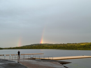 Bright rainbow high in sky over Lochwinnoch during dark storm