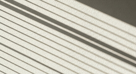 Textured white wall with diagonal shadow stripes creates modern abstract pattern