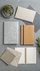 Flat lay of stationery and plant with textured elements notebook envelope
