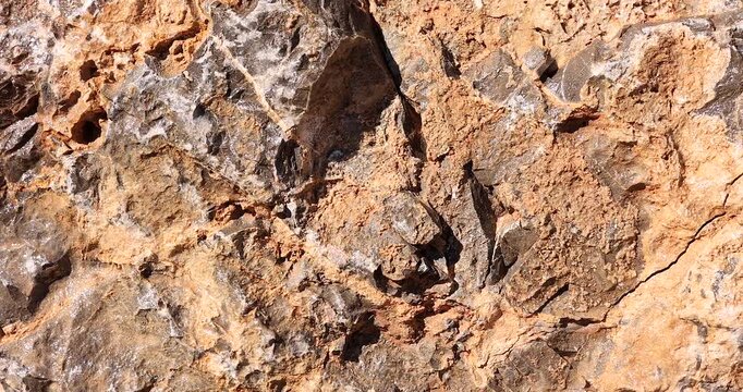 Close View of Rough Rock Face in bright Natural Light slider shot
