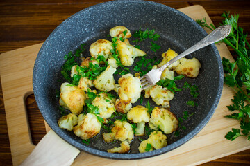 Fried cauliflower with spices and herbs in a frying pan