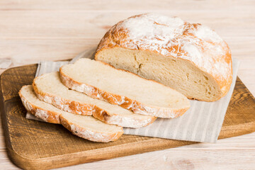 Assortment of freshly sliced baked bread with napkin on rustic table top view. Healthy unleavened bread. French bread slice