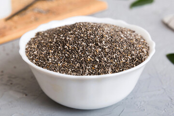 Chia seeds in bowl and spoon on colored background. Healthy Salvia hispanica in small bowl. Healthy superfood
