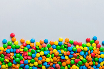 Mixed collection of colorful candy, on colored background. Flat lay, top view. frame of colorful chocolate coated candy