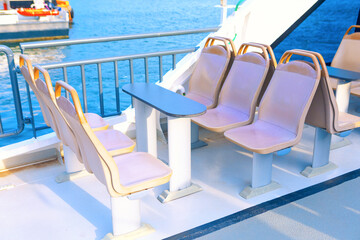 Outdoor seating on a boat deck, with a table in between. Row of seats perfect for a relaxing ferry...