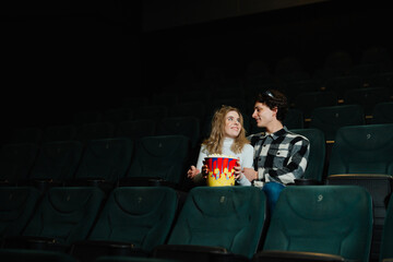 Young couple enjoys a movie night at the cinema with popcorn