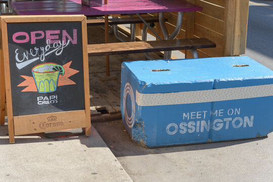 sidewalk chalkboard sign outside Papi Chulo's, a Mexican restaurant, located at 121 Ossington Av, Toronto (with painted block and slogan)