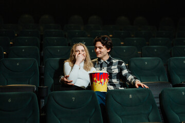 Couple enjoys a movie together in an empty theater during evening hours