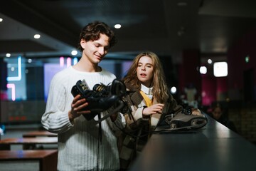 Young skaters prepare for an evening session at an indoor rink in winter