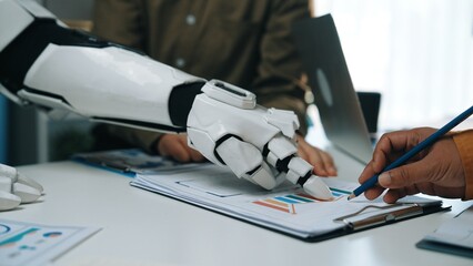 A dynamic interaction between a human and a robotic arm in a sleek office setting, symbolizing the future of collaboration and technological innovation in workspaces.Noogenesis
