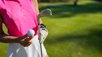 Golfer prepares to strike a ball while standing on a lush green fairway