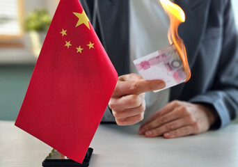 Individual burns currency while holding Chinese national flag in an act of protest