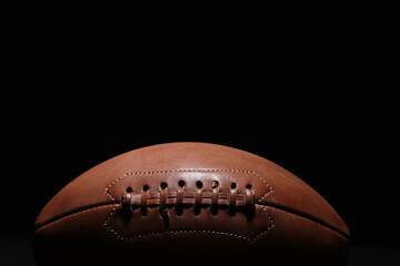 American football leather ball on, black background. Game equipment horizontal sport theme poster, greeting cards, headers, website and app